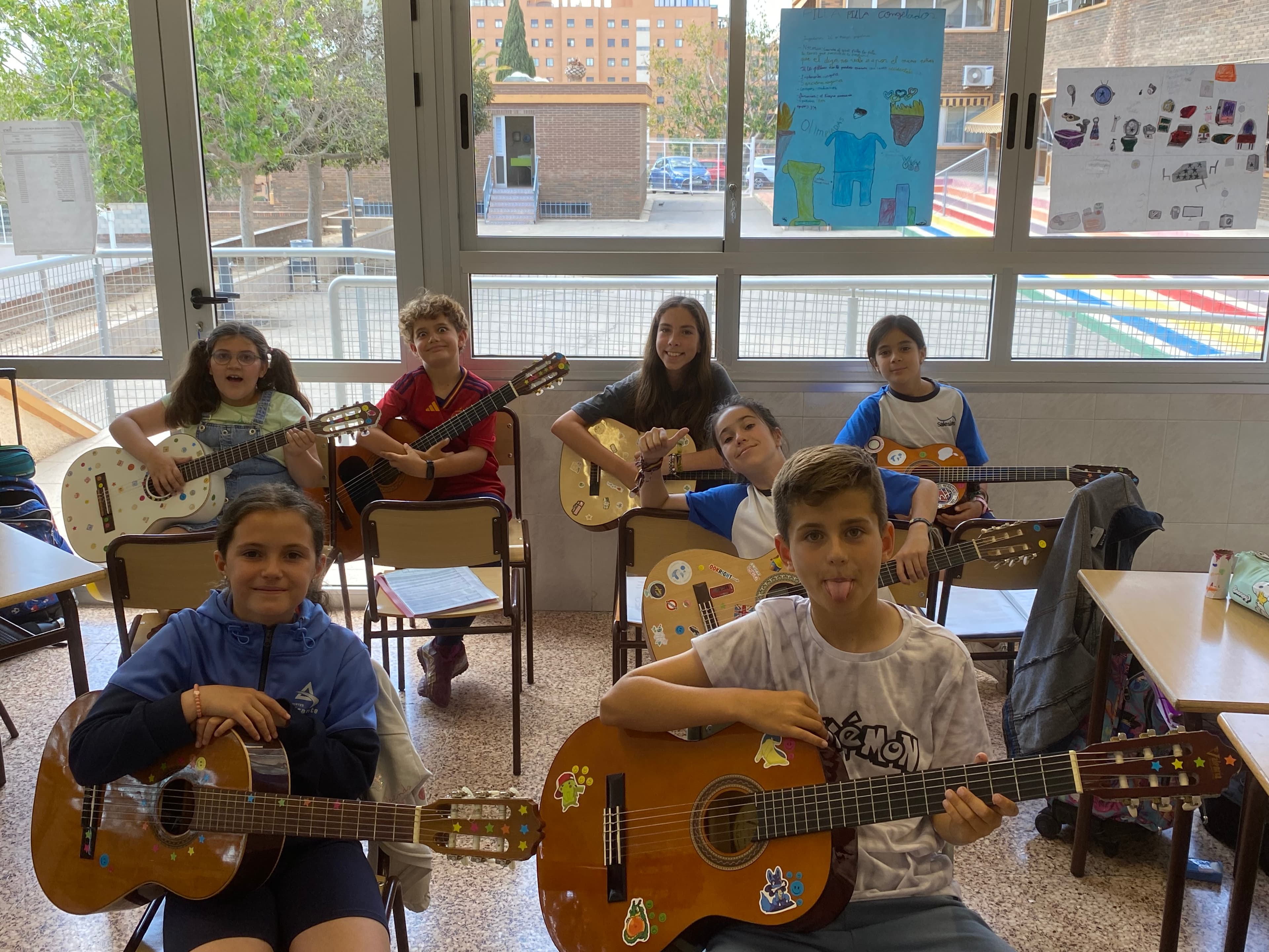 Niños tocando guitarra en actividad extraescolar