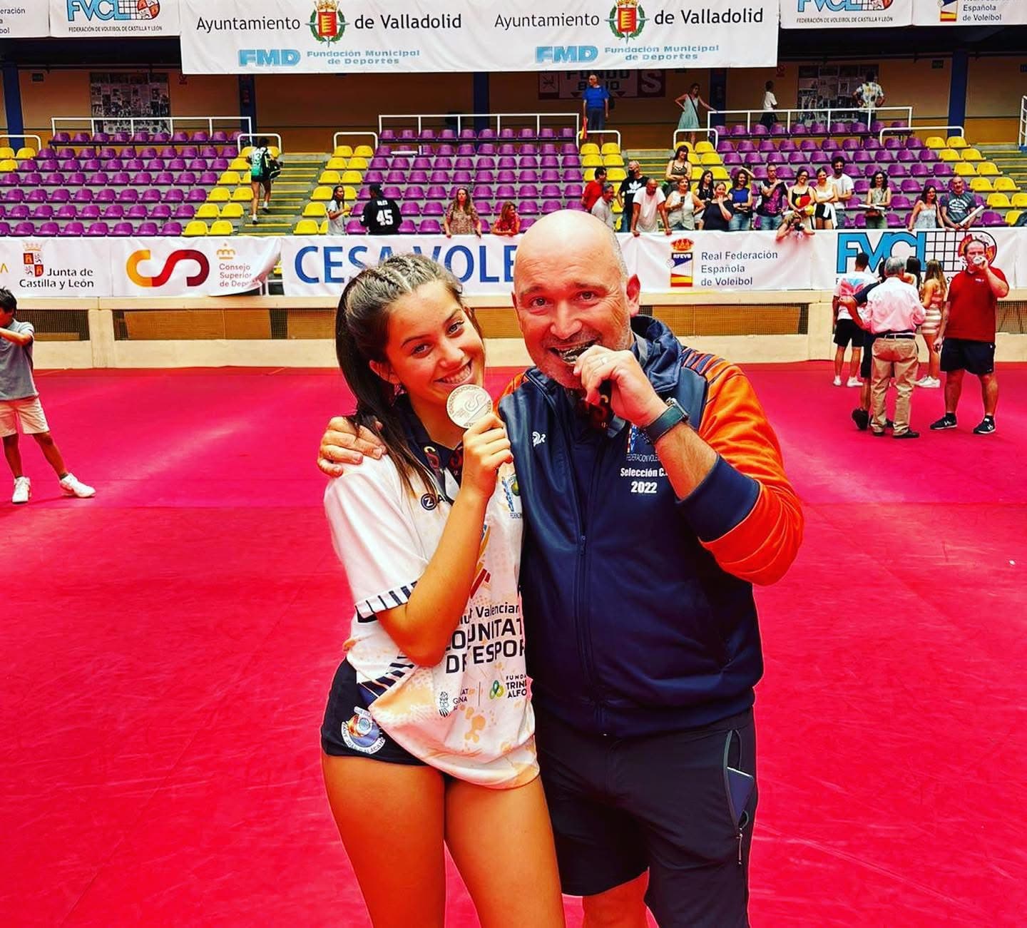 Entrenador con atleta medallista